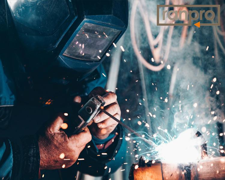 A welder using Ranpro welding tools and protective gear in a workshop, showcasing the precision and safety of their equipment.